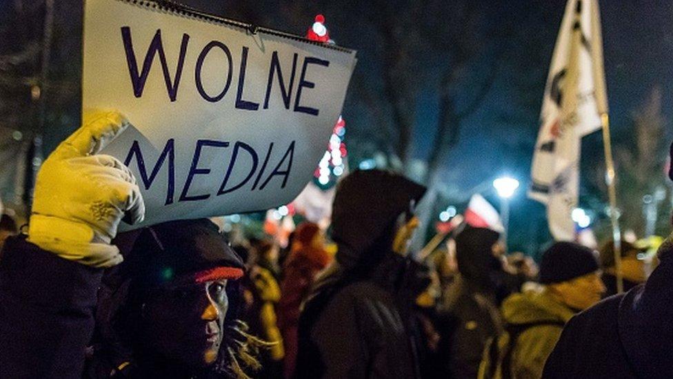 A protester holds a sign reading 'Free media' as people gather for an anti-government demonstration by opposition supporters outside the Polish parliament on 16 December 2016.