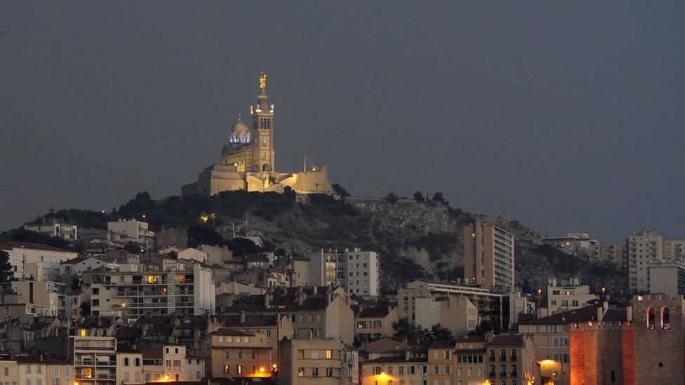 Dark smoke passing above Notre Dame de la Garde Basilica and the Vieux Port in Marseille. August 10, 2016