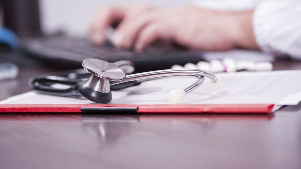 A GP's hands with a stethoscope