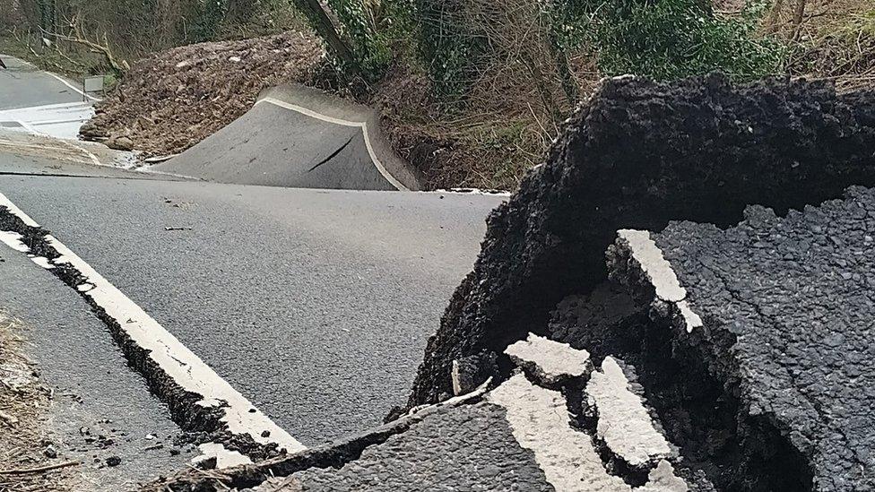 Damaged road showing cracked tarmac