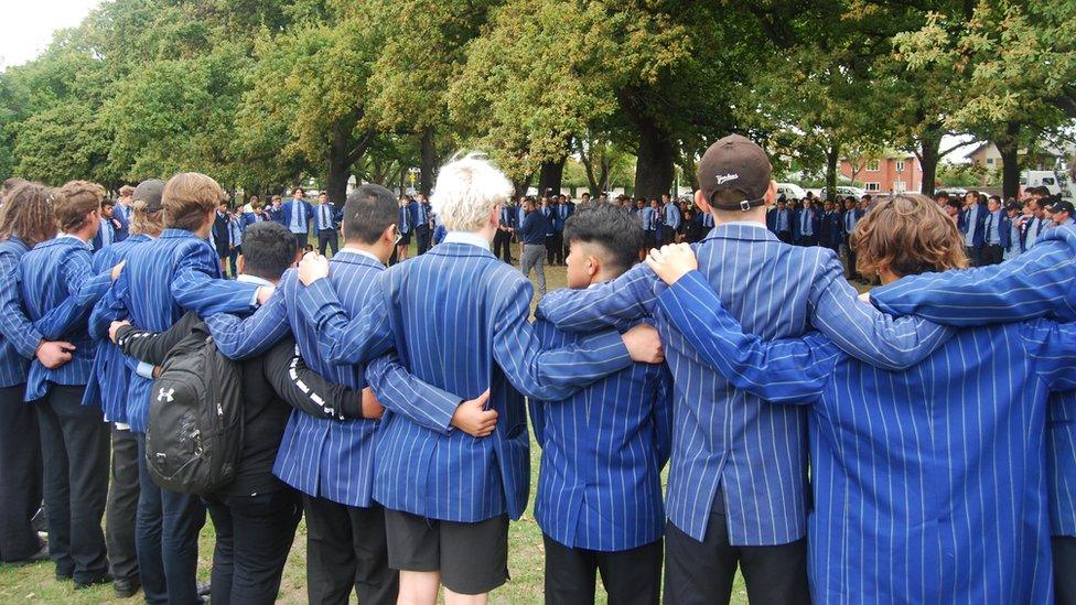 Schoolchildren link arms at a vigil in Christchurch