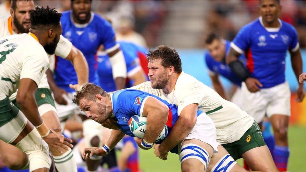 Namibian player Wian Conradie is tackled during a Group B game against South Africa.