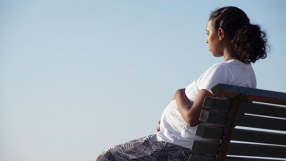 Pregnant woman sitting on a bench