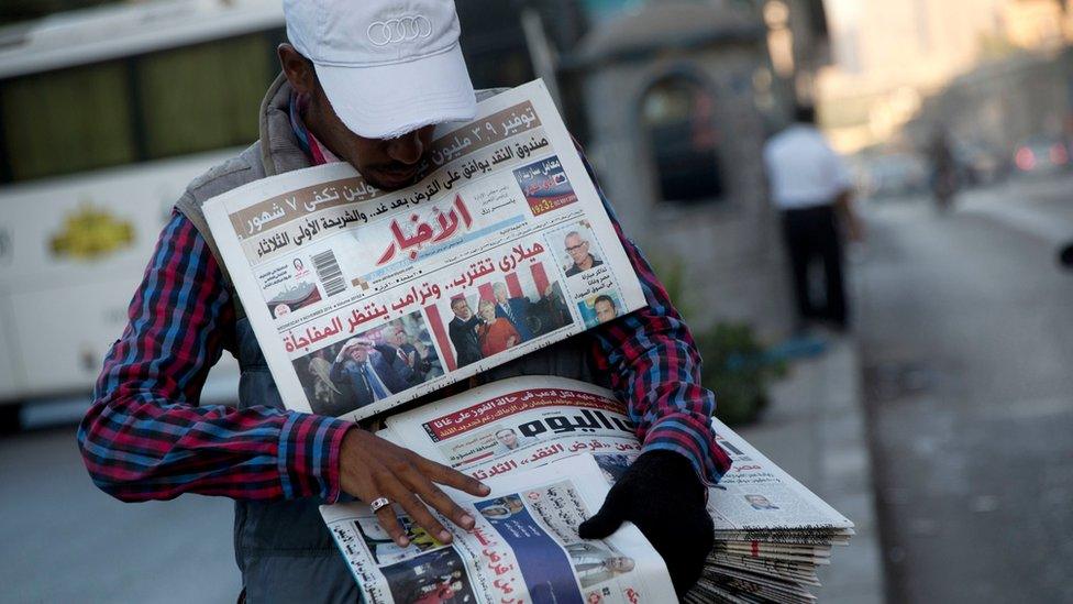 An Egyptian newspaper vendor holds local papers on 9 November 2016