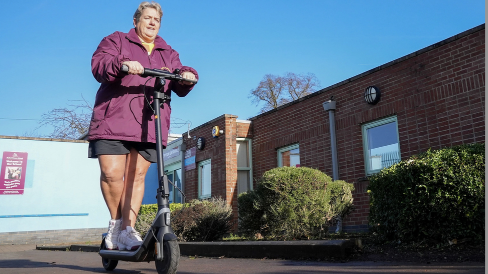 Cas Evans riding an electric scooter