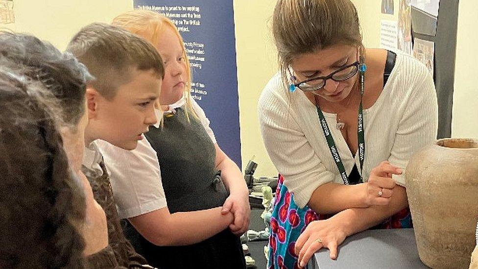 Children get a close-up view of the canopic jar at school