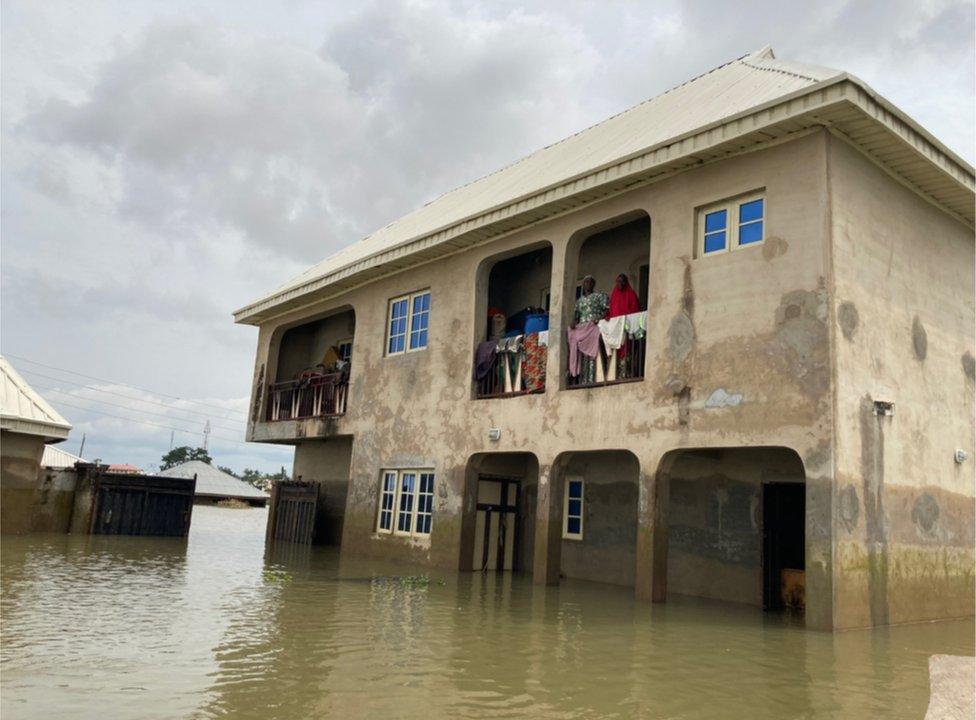 People standing on the second-floor balcony of Mohammed Sani Gambo's house.