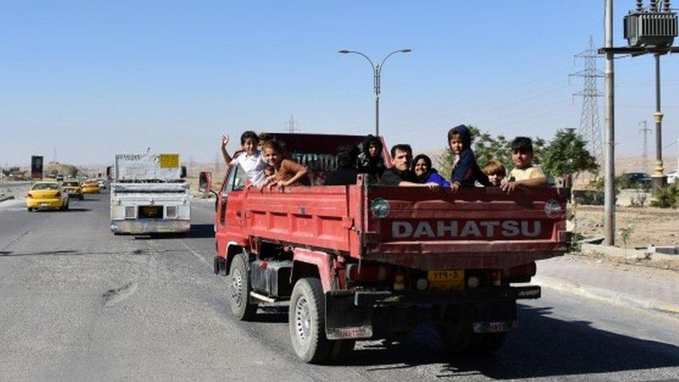 Kurdish families, who fled their homes in Kirkuk the day before, pass through a checkpoint as they make their way back to their homes (17 October 2017)