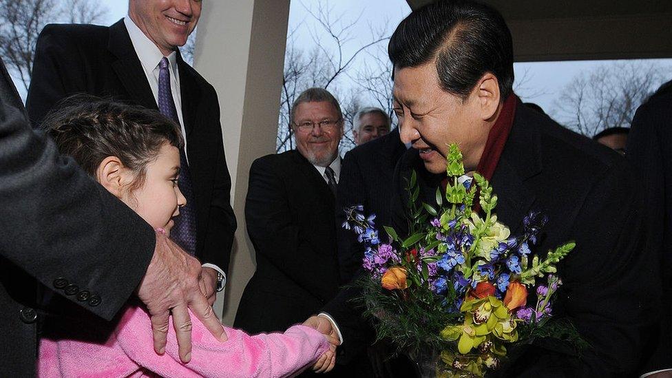 Xi Jinping receives flowers from a young girl in Iowa during a 2012 trip to the state