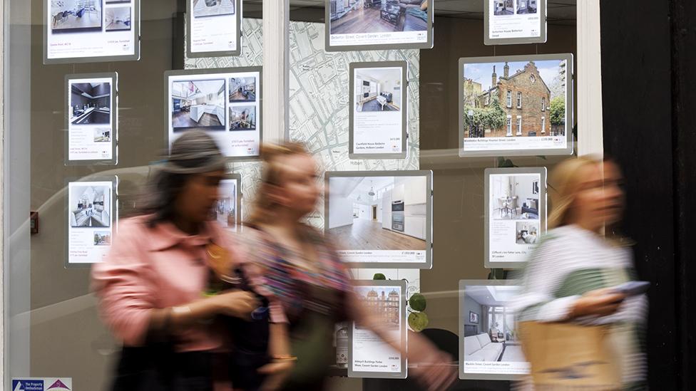 People walk past an estate agents window in London on 5 October