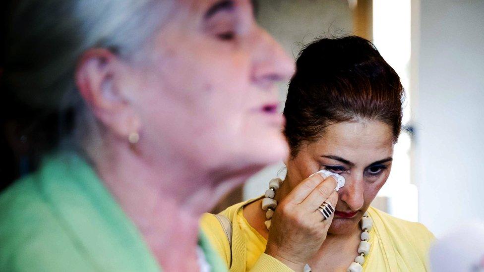 A woman wipes a tear away outside court in the Netherlands