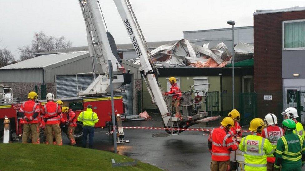 Firefighters around damaged roof
