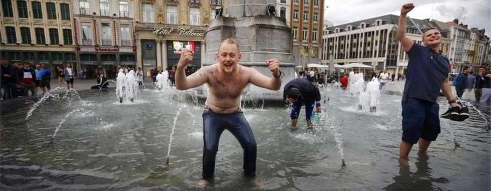 England fans celebrate their team's win in a fountain in Lille