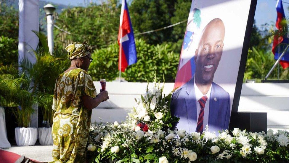 A supporter of Haitian President Jovenel Moise prays at a memorial marking the first anniversary of his assassination, in Port-au-Prince