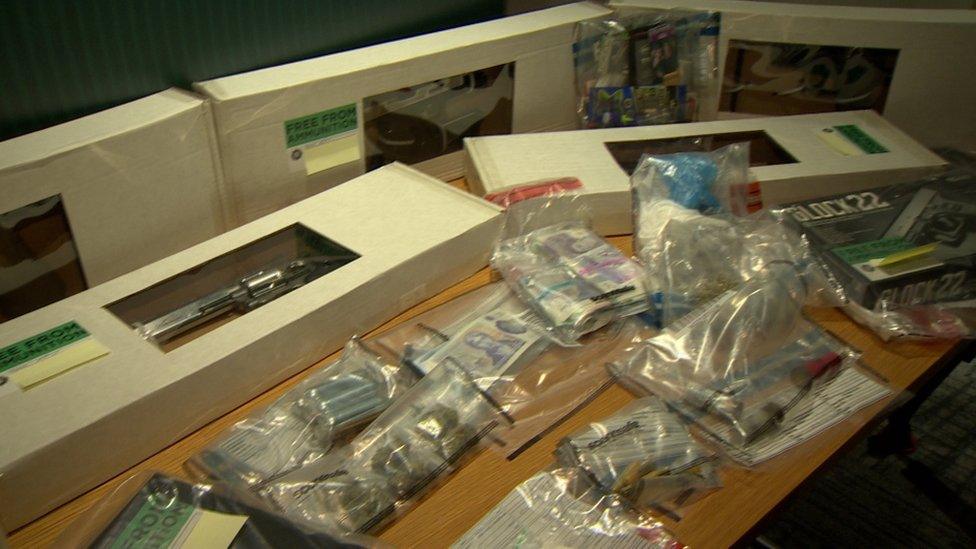 The table showing the seizure made by police - drugs, money. guns and swords shown