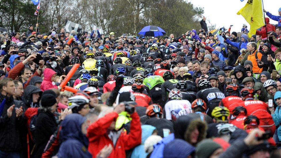 Riders cycle through crowds