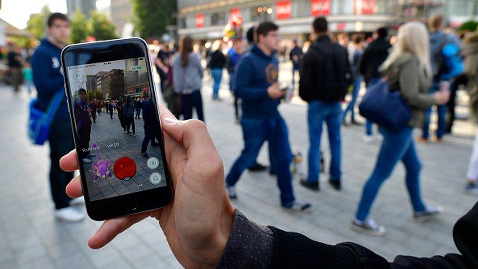 A man playing Pokemon Go in the street