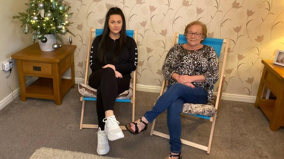 Janet Mellor and her daughter Katie sit on deckchairs in their living room