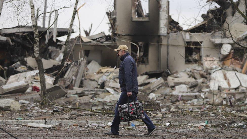 A man goes past burned buildings that were hit by shelling in the small city of Borodyanka near Kyiv, Ukraine