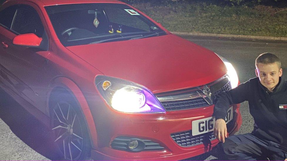 Lewis Burtney with his red Vauxhall car