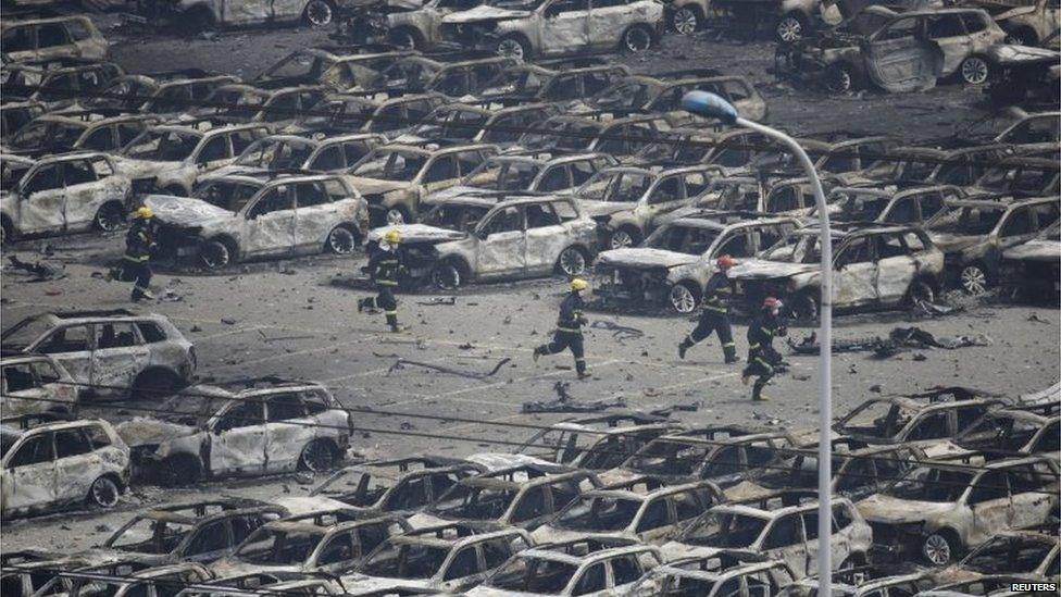 Firefighters run through charred cars in Tianjin, China (14 Aug 2015)