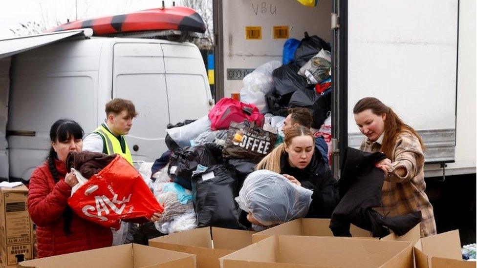 Volunteers pack donations of essential goods and clothing at the Tesco Express car park, from where the lorry will be driven to Ukraine once filled, in Northampton