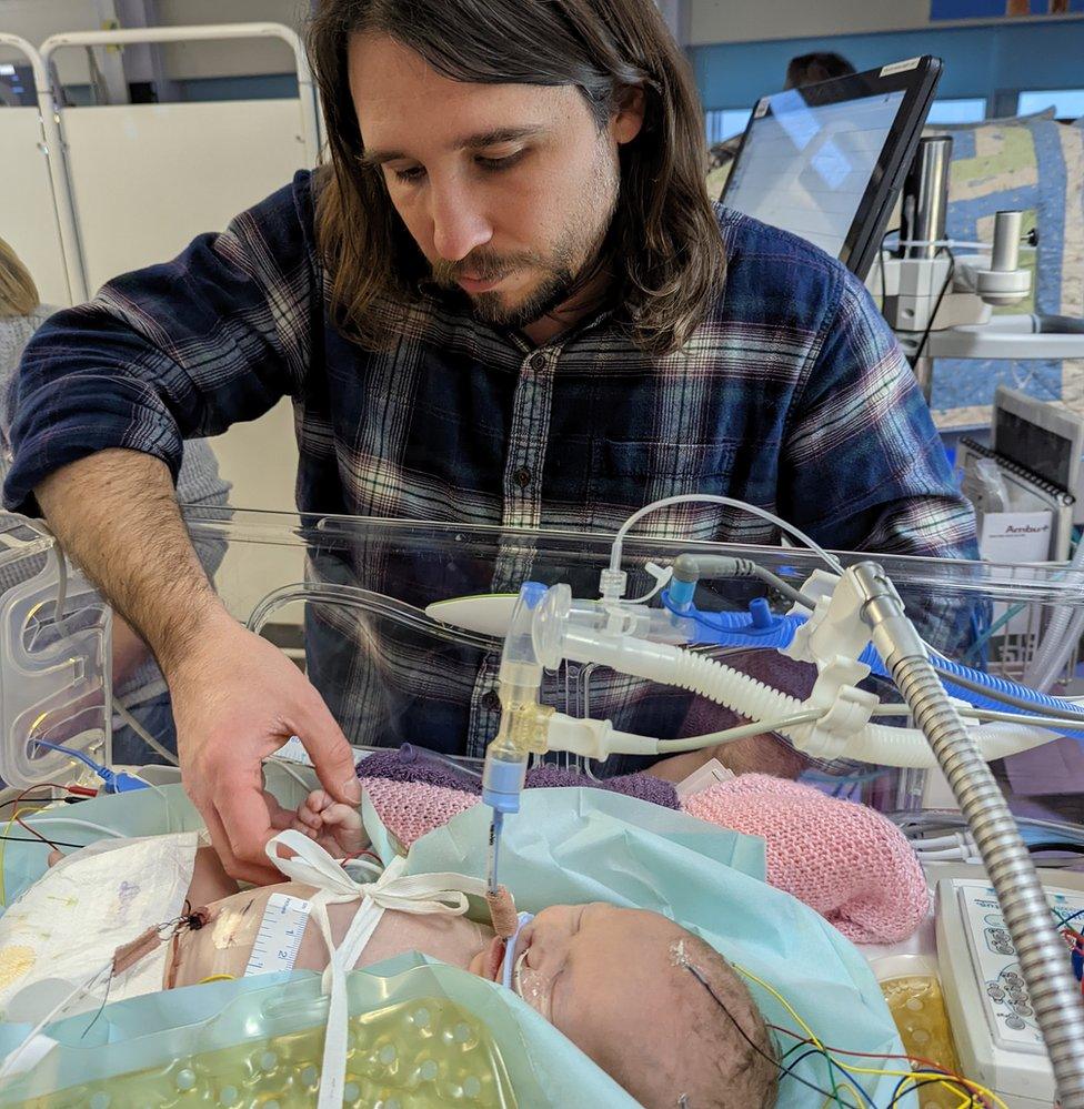 Robert Miller holding Abigail's hand in hospital