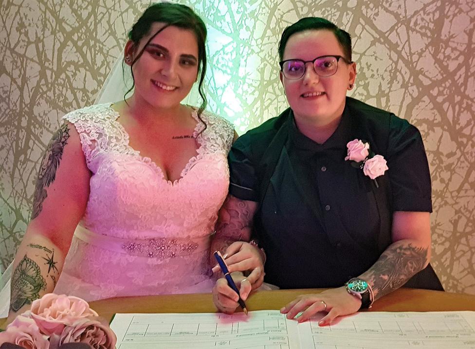 A wedding couple sign their marriage certificate