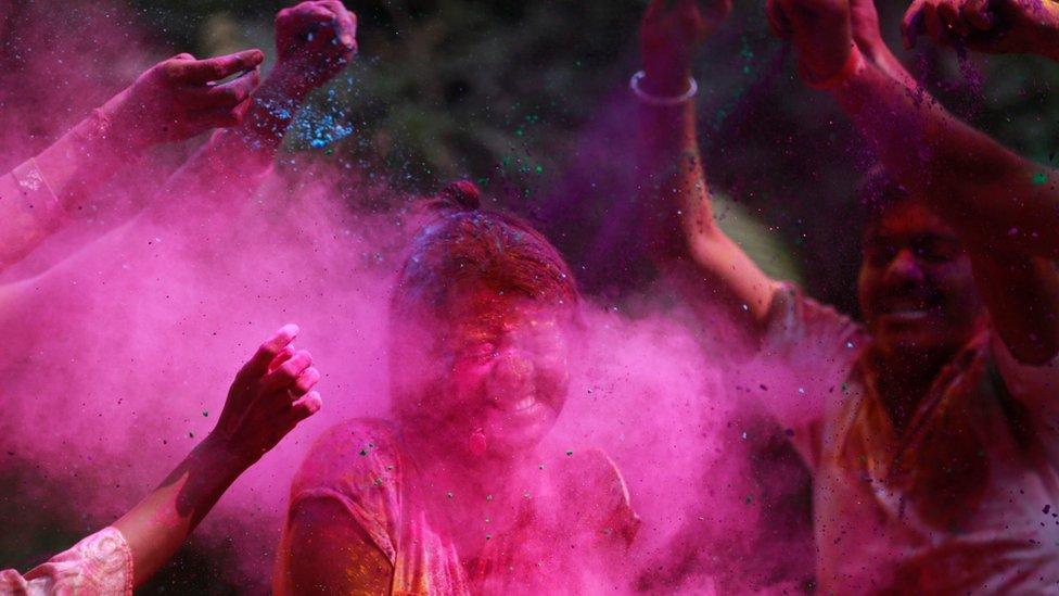 People throw paint during the festival of Holi