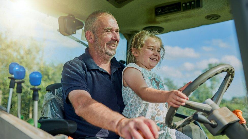 child-with-dad-on-a-tractor