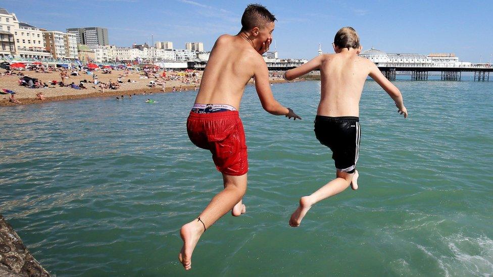 Two boys jump into the sea in brighton