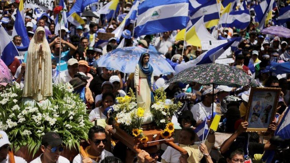 Demonstrators hold national flags during a march in support of the Catholic Church in Managua, Nicaragua July 28, 2018.