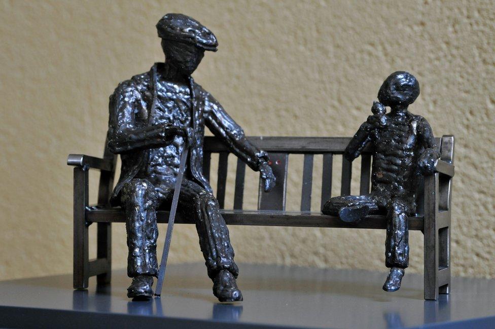 Model of a man telling his grandson about his memories of ships being launched on the River Wear