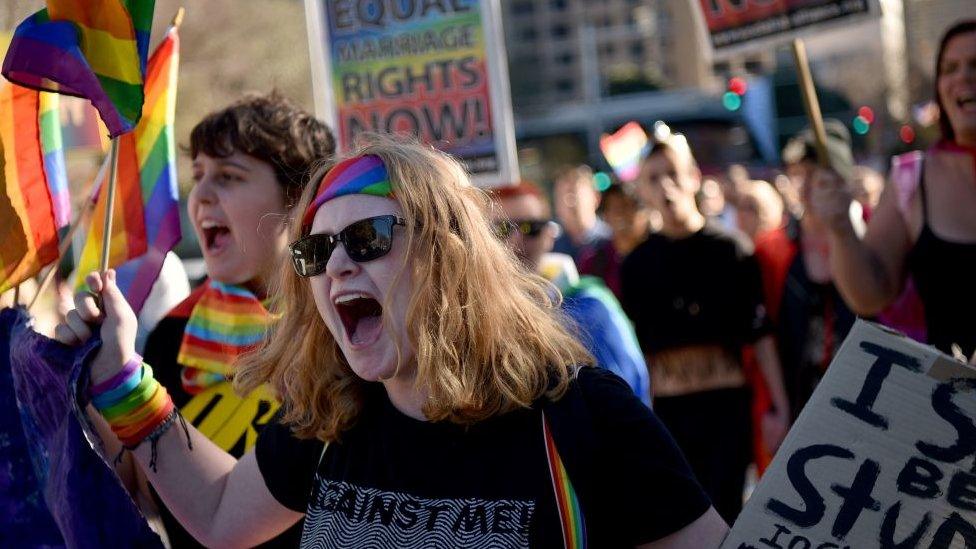 Supporters of same sex marriage carry banners and shout slogans as they march in Sydney on August 6, 2017.