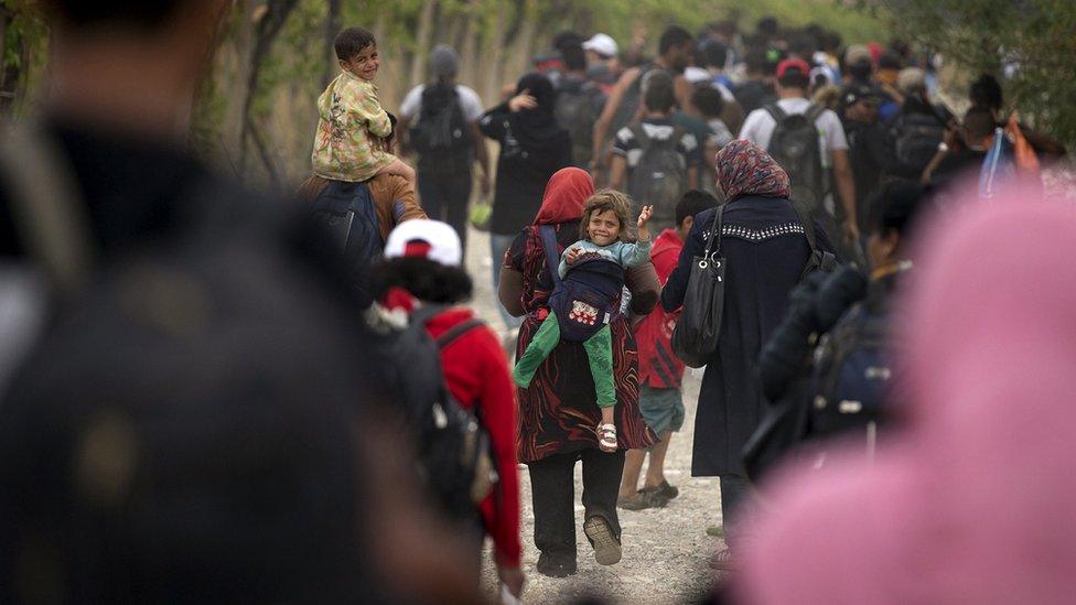 Migrants walk on a dirt road after crossing the Macedonian-Greek border near Gevgelija, Macedonia (06 September 2015)