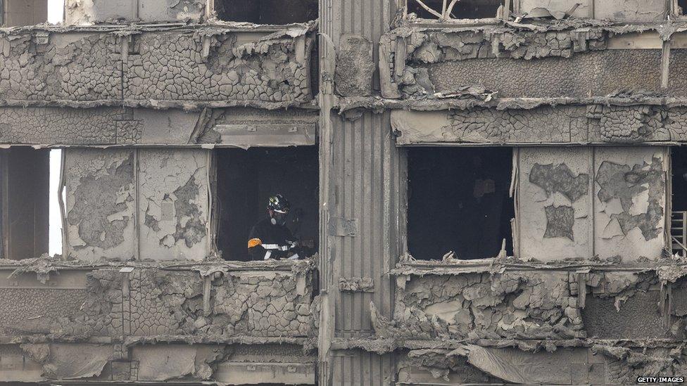 A firefighter works through the rubble of Grenfell Tower