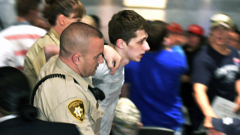 Police remove Michael Sandford from Donald Trump's campaign rally at the Treasure Island Hotel Casino in Las Vegas, Nevada, 18 June