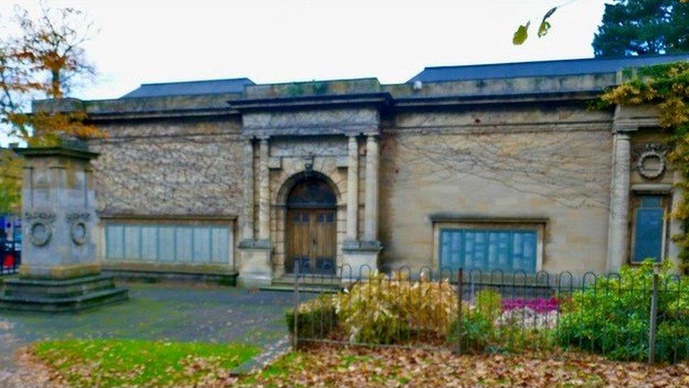 Grey stone building with pillared entrance porch