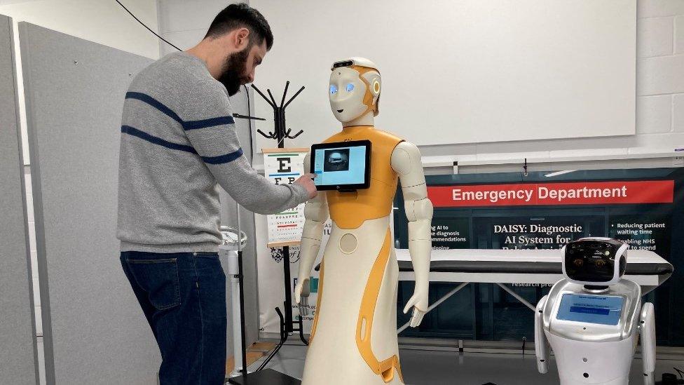 Professor Miles Elsden pictured adjusting a robot