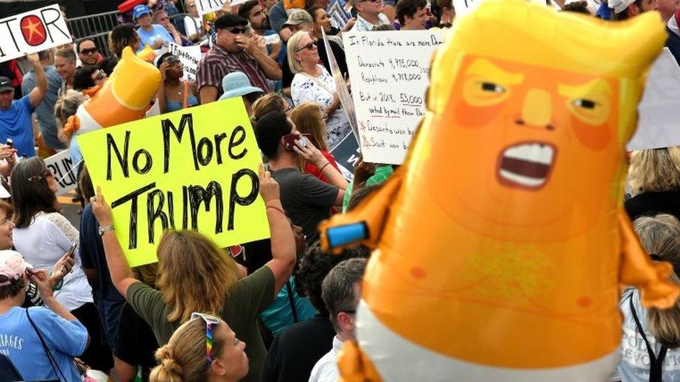 Opposition groups protest against President Trump with mini baby blimp in shot