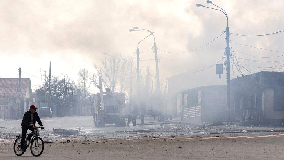 A man rides a bike in front of a building after it was hit by shelling in Lysychansk, Luhansk region, Ukraine, 16 April 2022