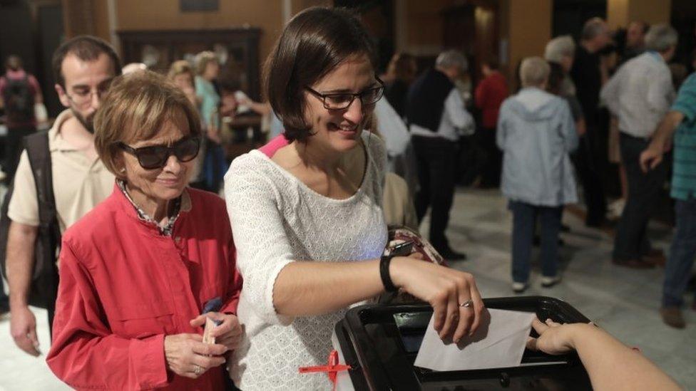 Two women cast their ballot in the referendum vote at Escola Industrial of Barcelona school polling station on October 1, 2017 in Barcelona, Spain