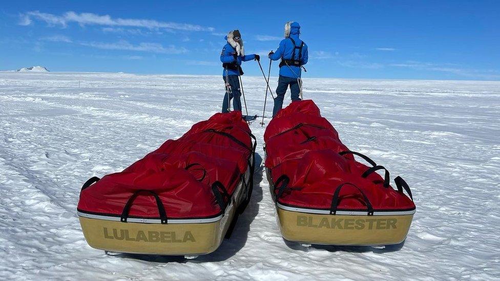 justin and jamie in the antarctic with their gear on sleds behind them