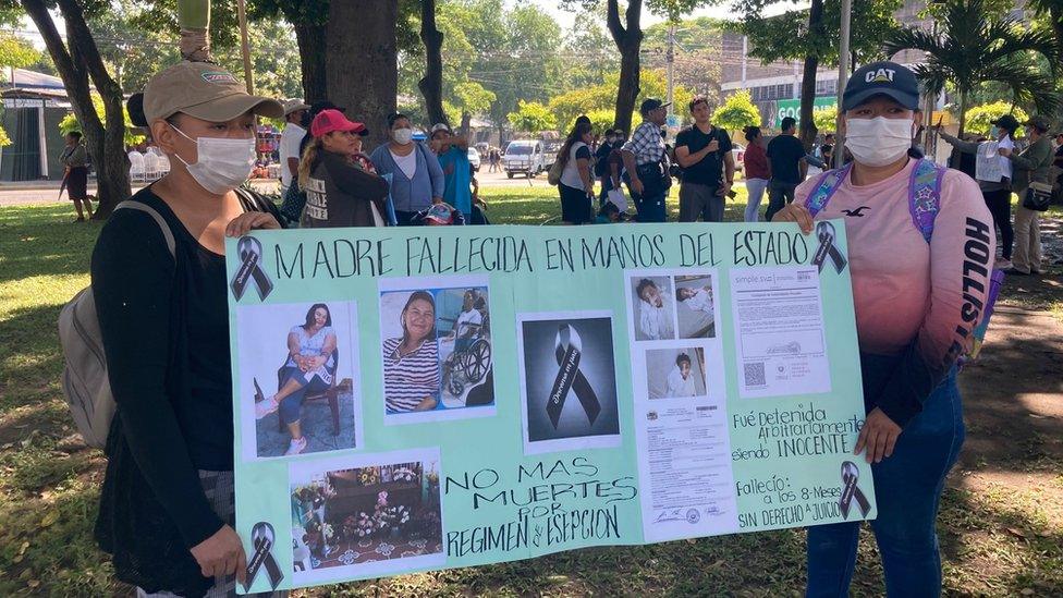 Eva Sandoval holds a placard commemorating her sister Noeli