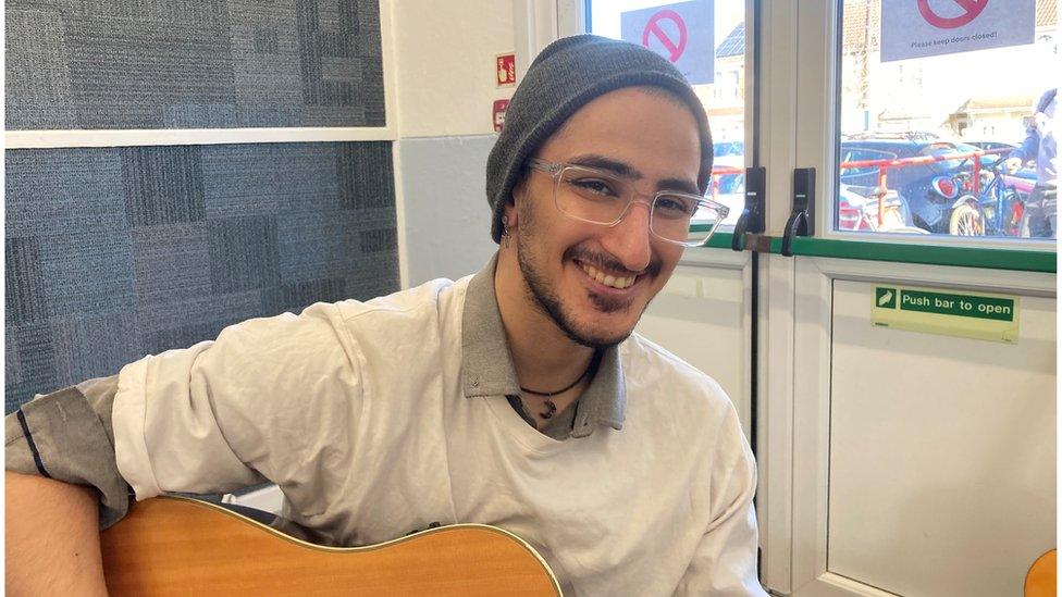 Picture of Faraz smiling with his guitar