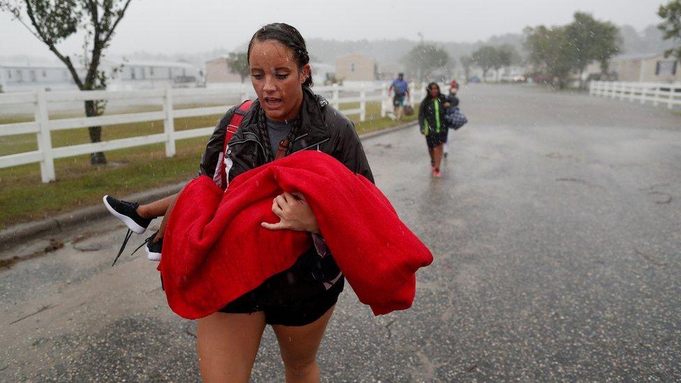 Maggie Belgie of The Cajun Navy carries a child evacuating a flooding trailer community during Hurricane Florence in Lumberton, North Carolina, 15 September 2018