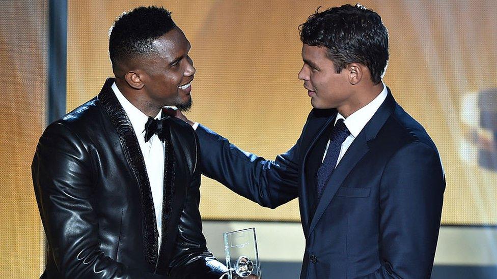 Brazil defender Thiago Silva (R) receives an award from Cameroon Samuel Eto'o