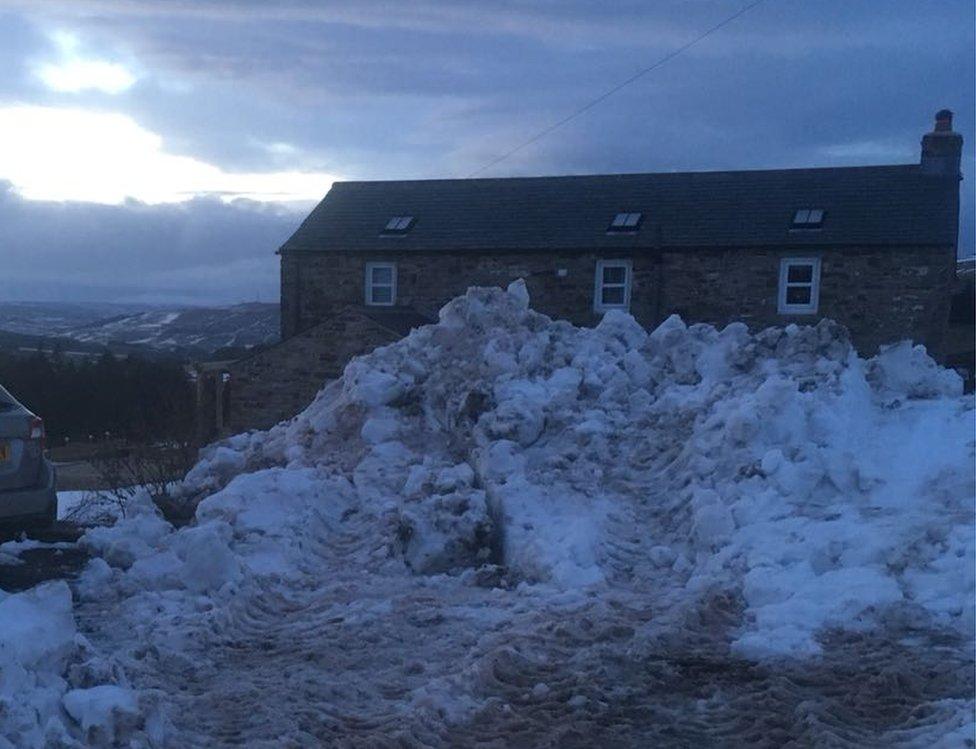 House with a huge drift of snow in front of it