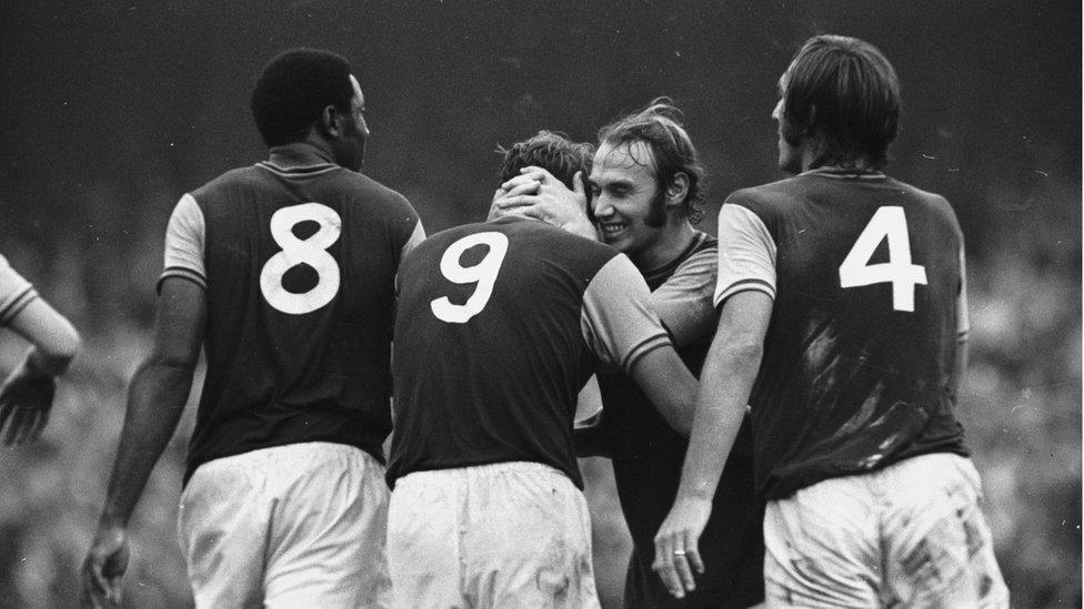 West Ham's Bryan 'Pop' Robson hugs the England hero Geoff Hurst after he equalises in a match against Leicester City at Upton Park