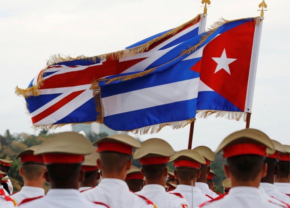 Union Jack and Cuban Flag flutter in the air above the guards